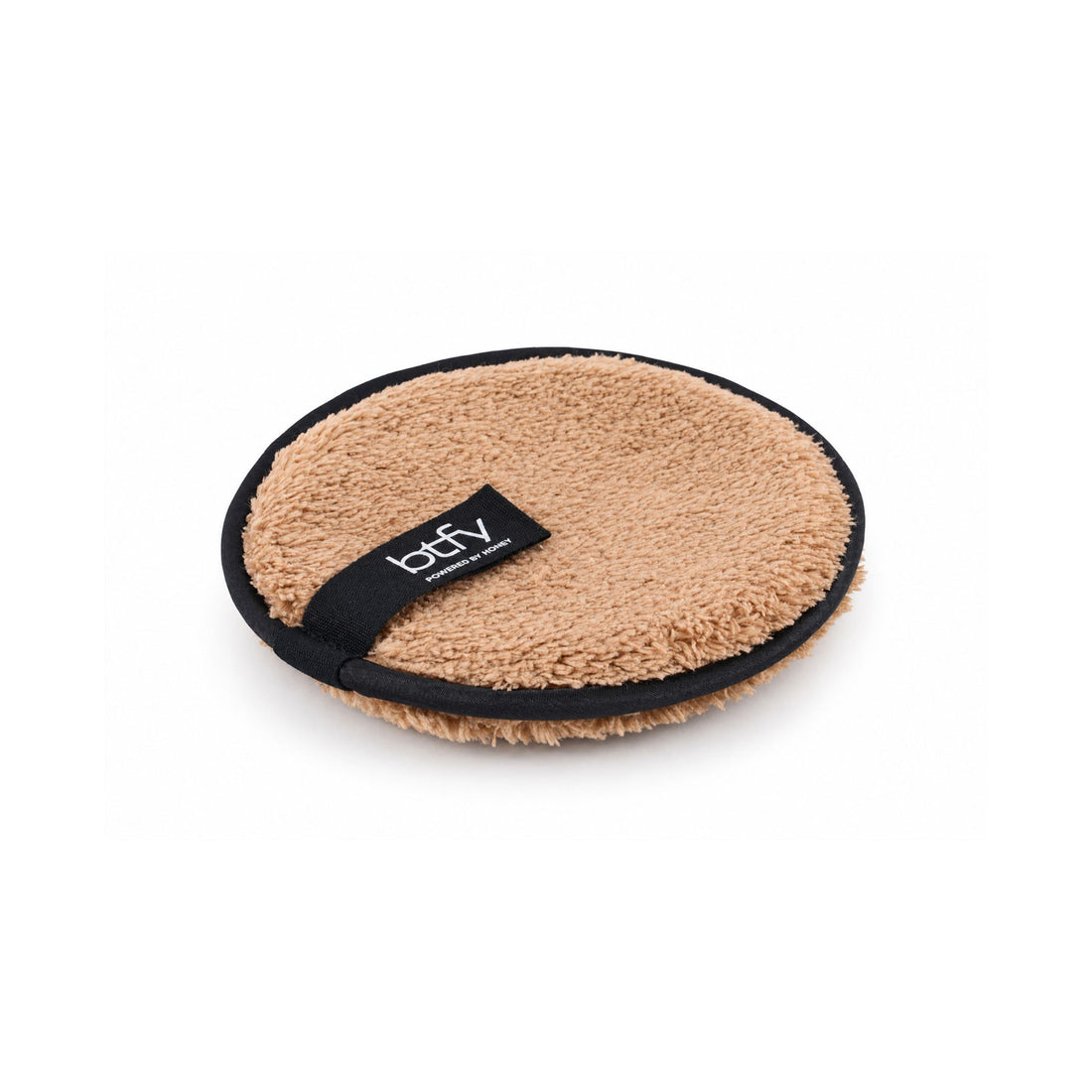 BTFY reusable Makeup Remover Puff, angled view, round plush honey-coloured microfibre with black trim and a BTFY Powered by Honey tab